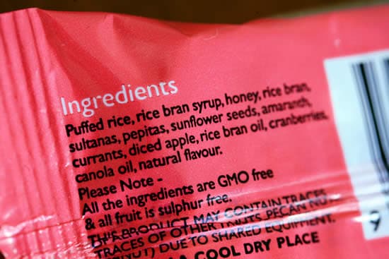 The back of a processed food package, showing an ingredients list with multiple types of sugar: rice bran syrup and honey.