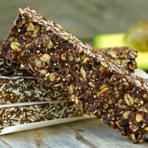 Stack of Chocolate Avocado Breakfast Bars with an avocado in the background