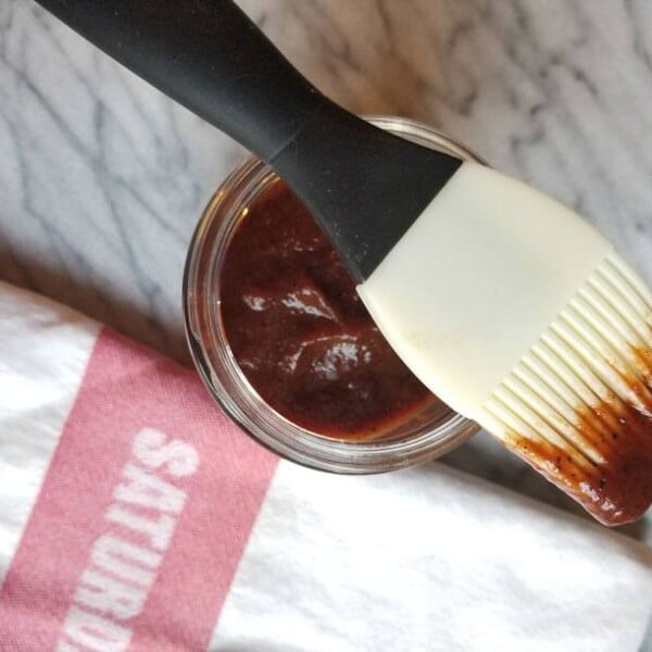 bbq sauce in a jar with a pastry brush